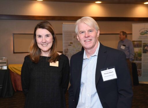 A man and a woman formally dressed standing side by side with name tags on.