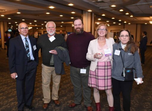 Group of formally dressed men and women posing for a picture.