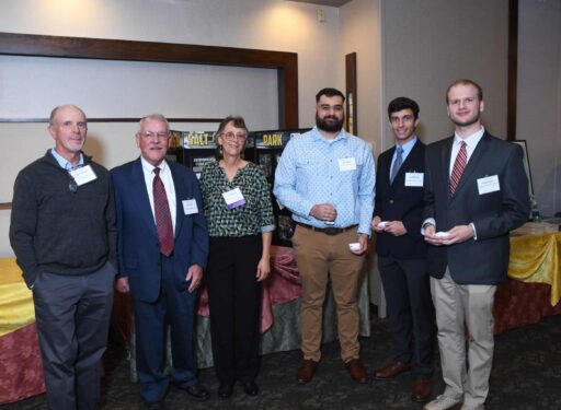 Group of formally dressed people posing for a picture.